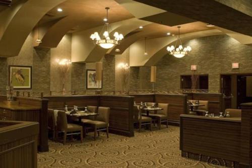 a restaurant with tables and chairs and chandeliers at Pahrump Nugget Hotel & Casino in Pahrump