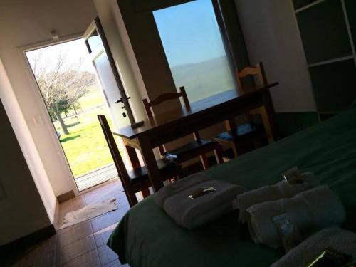 een slaapkamer met een groen bed met uitzicht op de oceaan bij Complejo Cabañas Cerro Redondo in Tandil