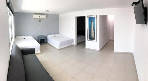 ein Hotelzimmer mit 2 Betten und einem Sofa in der Unterkunft Mona Inn in Mazatlán