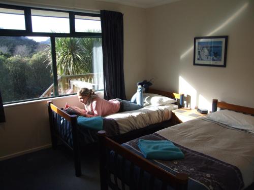 a young girl laying on a bed in a bedroom at Anakiwa Lodge in Anakiwa