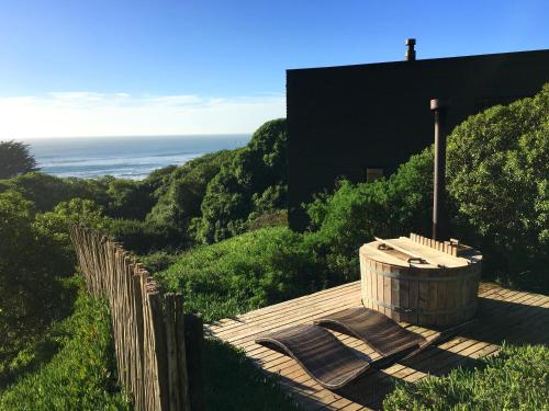 a wooden deck with a hot tub on top of a hill at OMZ - Olas de Matanzas in Matanzas