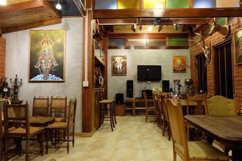 a dining room with tables and chairs and a television at Klong Suan Plue Resort in Phra Nakhon Si Ayutthaya