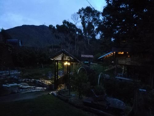 a night view of a building with a light on it at Cabaña en la Calera Cerezos in La Calera