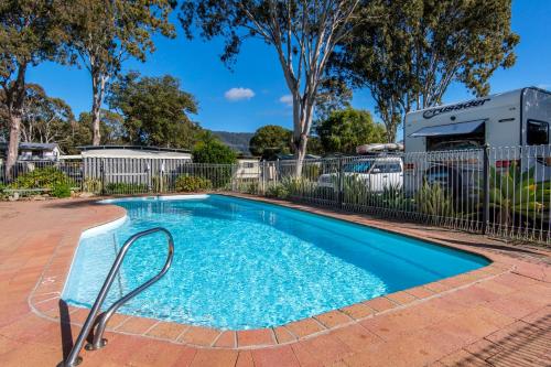 uma piscina num quintal com uma caravana em Dunbogan Caravan Park em Dunbogan