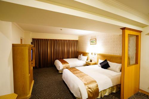 ein Hotelzimmer mit 2 Betten und einem TV in der Unterkunft Cambridge Tainan Hotel in Tainan