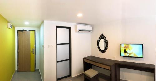 La salle de bains est pourvue d'un miroir, d'un lavabo et d'une porte. dans l'établissement Hotel Check-In, à Kuala Lumpur