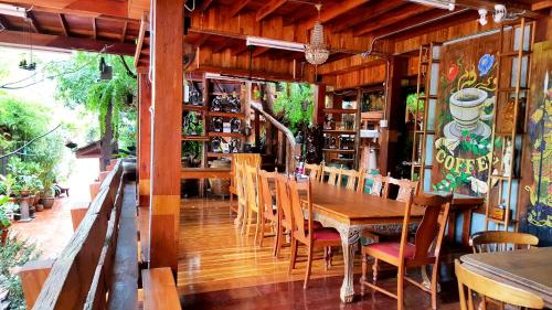 una sala da pranzo con tavolo e sedie in legno di Klong Suan Plue Resort a Phra Nakhon Si Ayutthaya