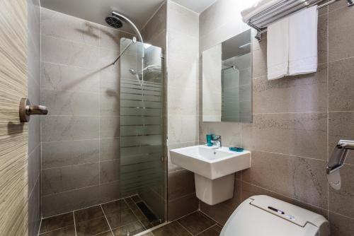 a bathroom with a toilet and a sink and a shower at Sea Stay Hotel in Jeju