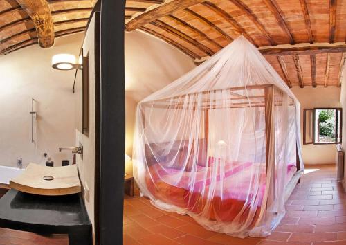 a bedroom with a bed with a mosquito net at Villa Amedeo in Rosia