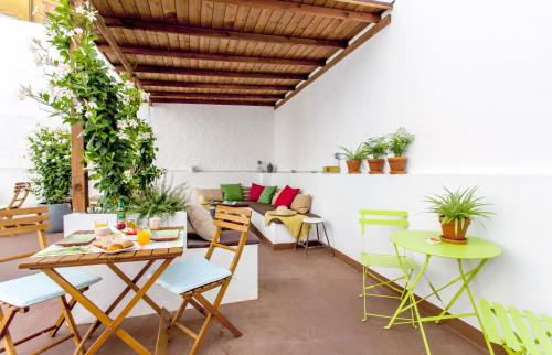 a patio with a table and chairs and a couch at City Garden Bed and Breakfast in Valencia