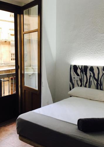 a bedroom with a bed and a window and a door at Alevia in Salamanca