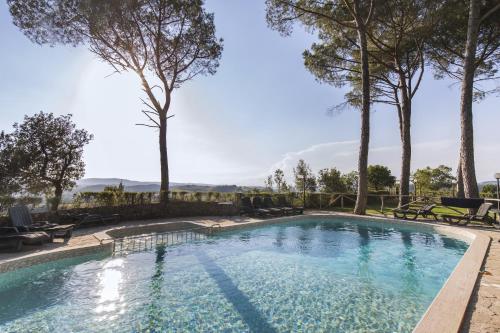 una piscina con alberi sullo sfondo di Villa Lecchi Hotel Wellness a Colle Val D'Elsa