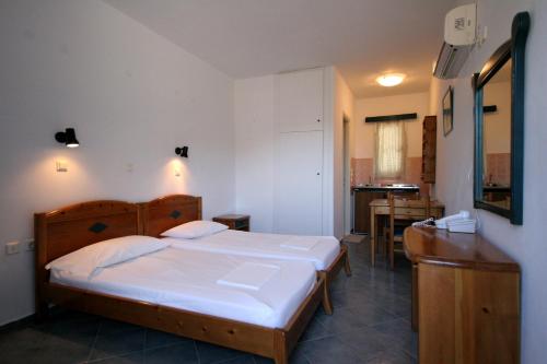 a bedroom with a large bed and a kitchen at Blue Horizon Studios in Lefkos Karpathou