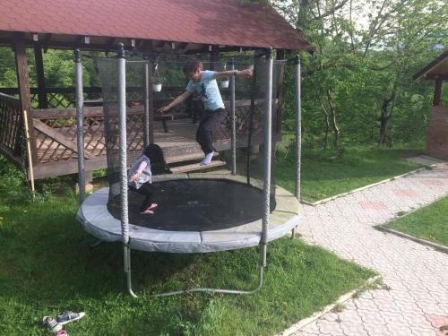 a man and a child playing on a trampoline at Cabana 7 Brazi in Poiana Mărului