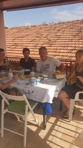 a group of people sitting at a table eating food at Guest Accomodation Žura in Skradin