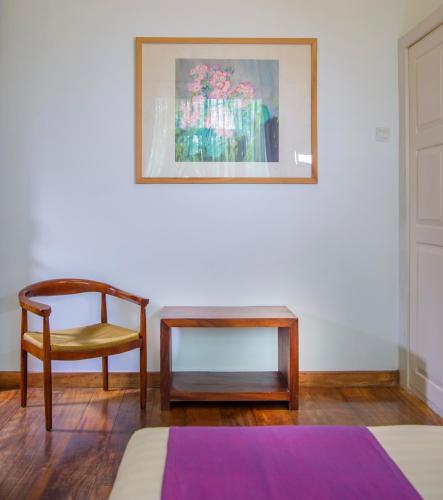 a room with a chair and a table and a picture at Zylan Colombo in Colombo