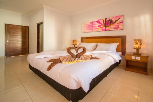 Un dormitorio con una cama grande y una decoración de corazón. en Griya Tunjung Sari, en Denpasar