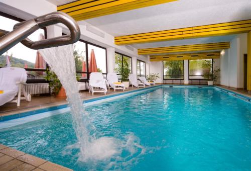 uma piscina com escorrega aquático em Vital & Wellnesshotel Schuerger em Thurmansbang