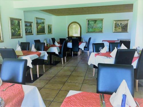 um restaurante com mesas e cadeiras num quarto em Hotel Pizzeria Selva em Zernez