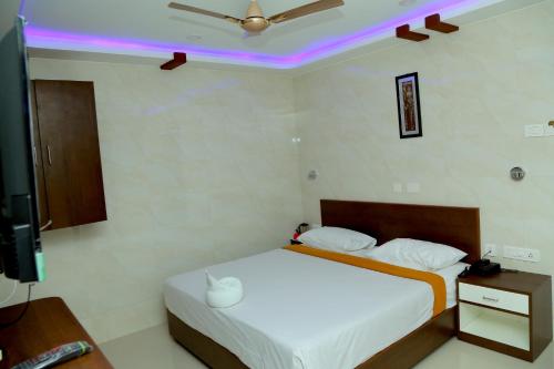 A bed or beds in a room at Sri Maharaja Residency