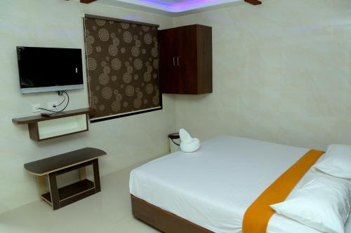 a hotel room with a bed and a tv at Sri Maharaja Residency in Tiruchchirāppalli