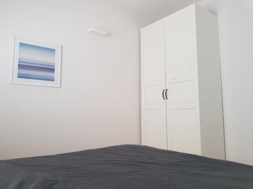 a bedroom with white cabinets and a bed at HaYarkon Street Apartment in Tel Aviv
