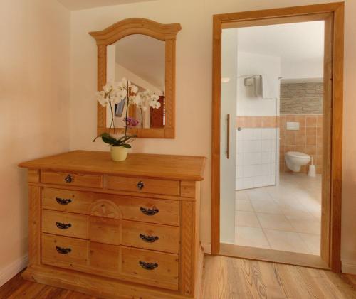 a bathroom with a wooden dresser and a mirror at Gasthof Ochsenwirt in Oberaudorf