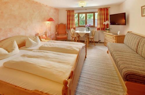 オーバーアウドルフにあるGasthof Ochsenwirtのベッド2台とテーブルが備わるホテルルームです。