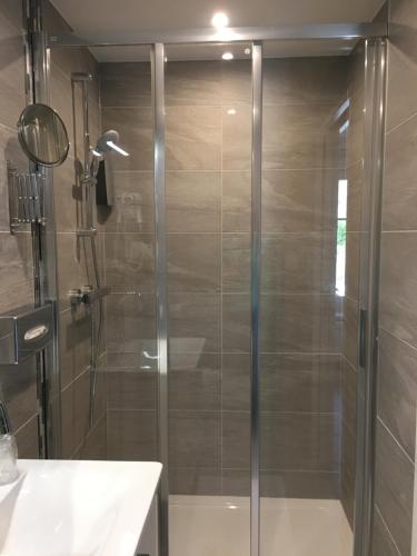 a shower with a glass door in a bathroom at Hotel Du Pont in La GrandʼCombe-Châteleu