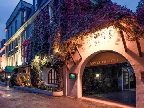 a building with flowers on the side of it at Mercure Paris Ouest Saint Germain in Saint-Germain-en-Laye