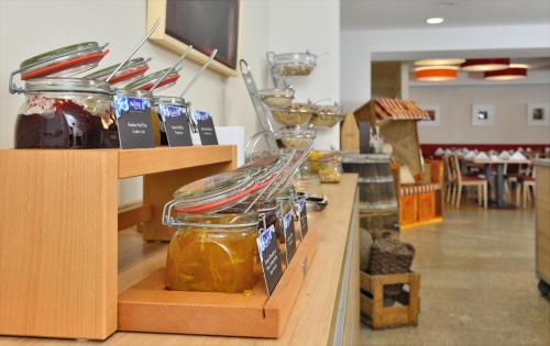 a counter with jars of honey and wine glasses at Aribo Hotel in Erbendorf