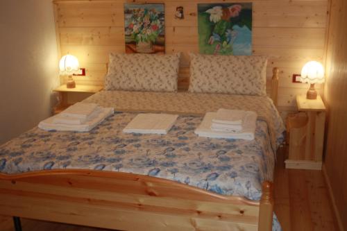 a bedroom with a wooden bed with two lamps at Albergo Diffuso Faller in Faller