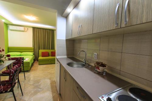 a kitchen with a sink and a couch in a room at De Lux Apartments Luka in Bar