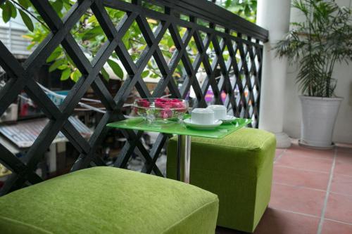 a green table and a green chair on a balcony at Hanoi Chic Boutique Hotel in Hanoi