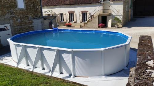 ein großer Pool in einem Hof mit einem Haus in der Unterkunft la ferme au ROY in Bernouil