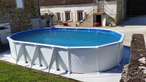 una grande piscina in un cortile con una casa di la ferme au ROY a Bernouil