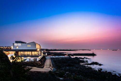 a building on the shore of a body of water at night at Sea Stay Hotel in Jeju