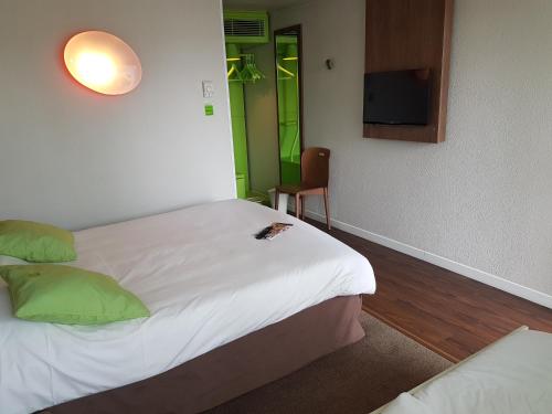 Habitación de hotel con cama y TV en Campanile Clermont-Ferrand Sud Issoire en Issoire