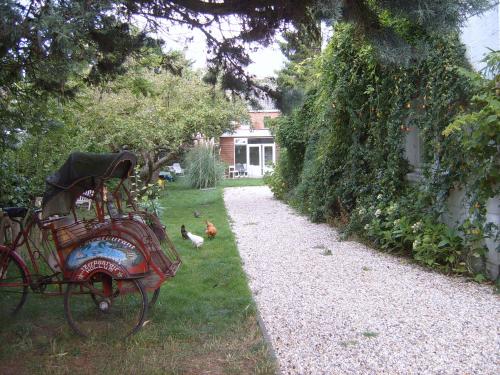 een tuin met een bank en kippen in het gras bij Achter het witte huis in Utrecht