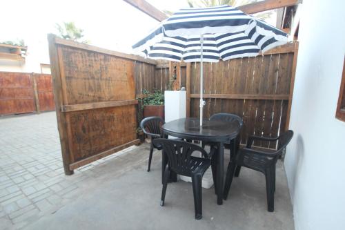 a patio with a table and chairs and an umbrella at Eazy Sleep Accommodation in Swakopmund