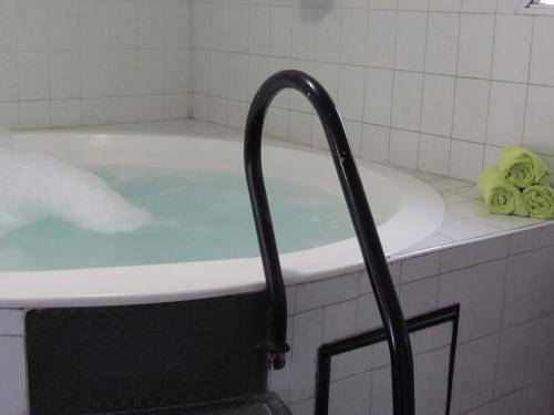 a bath tub filled with blue water in a bathroom at San Remo Grand Hotel in Mar del Plata