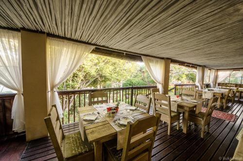 a dining room with tables and chairs on a deck at Lidiko Lodge in St Lucia