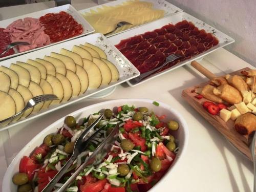 einen Tisch mit Platten verschiedener Arten von Lebensmitteln in der Unterkunft Boutique Hotel Sa Galera in Ca's Concos des Cavaller