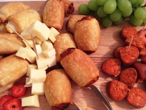 ein Haufen Essen auf einem Schneidebrett mit Weintrauben in der Unterkunft Boutique Hotel Sa Galera in Ca's Concos des Cavaller
