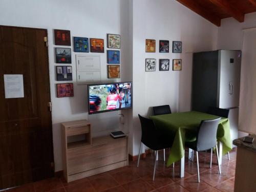 a dining room with a green table and a television at Casa Antonio in Valle Gran Rey