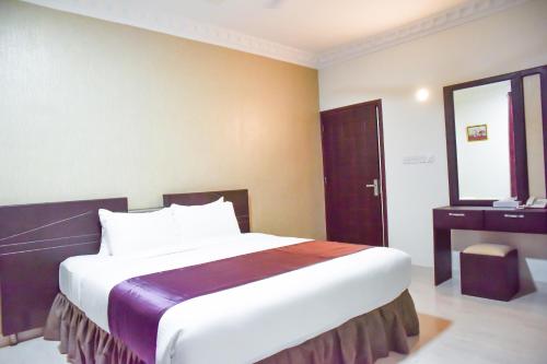 塞拉萊的住宿－Gateway Salalah Apartments，酒店客房设有一张大床和一张书桌。