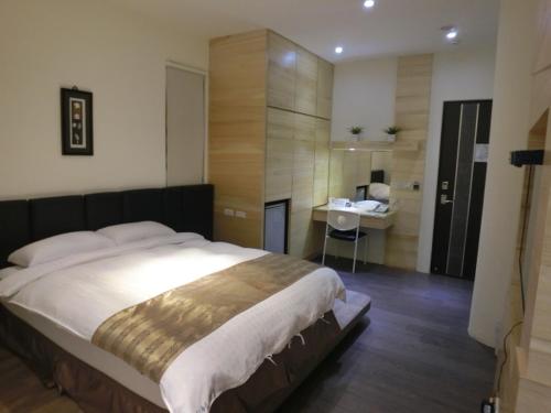 sypialnia z dużym łóżkiem i biurkiem w obiekcie Happy Hotel w mieście Lugang