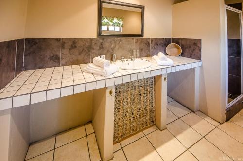 ein Bad mit einem Waschbecken und einem Spiegel in der Unterkunft Lidiko Lodge in St Lucia
