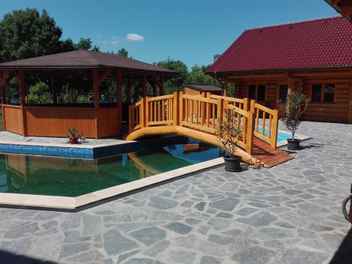 un puente de madera sobre una piscina junto a una casa en Penzion U Fábů, en Lednice