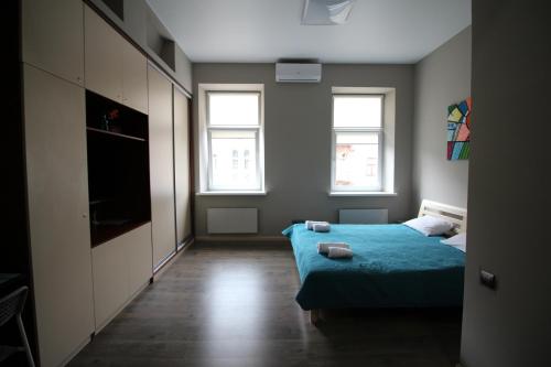 sypialnia z łóżkiem i telewizorem oraz 2 oknami w obiekcie Cosy Apartment on Horodotska 86 w Lwowie